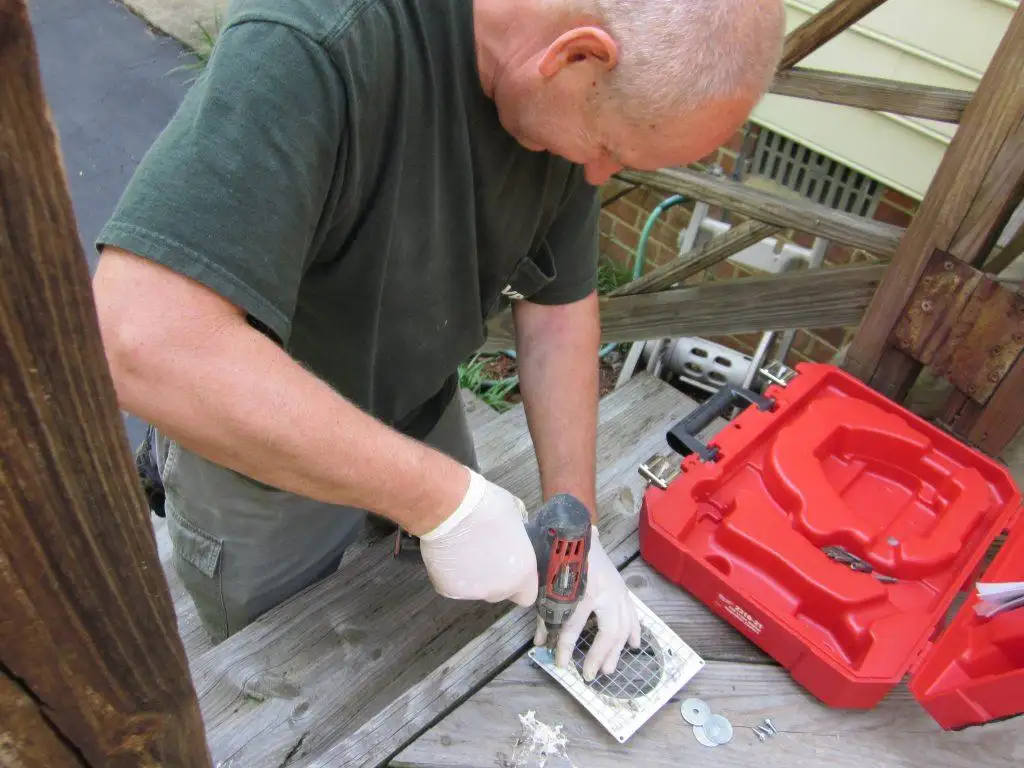 Wildlife technician preparing a bird-resistant exterior vent cover